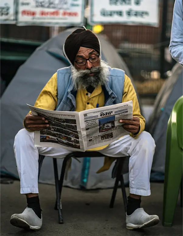 A man sitting reading a newspaper