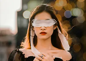 A woman blindfolded with a white scarf